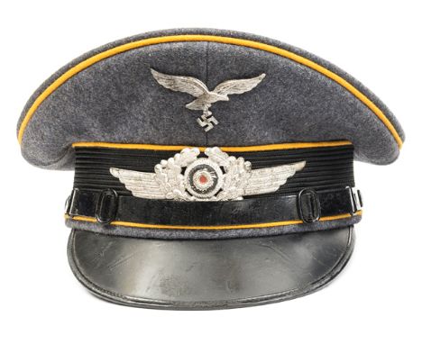 A Third Reich Luftwaffe Flight Section NCOs peaked cap, with metal insignia, golden yellow piping, patent leather strap, and 