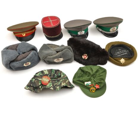A Russian Army fur cap, 2 similar with artificial fur; a Russian officer’s peaked cap; 2 other Eastern Bloc caps; a French ke