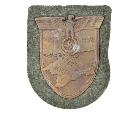 A Third Reich Krim shield,   on field grey patch with paper backing. GC unissued (small patch of corrosion). 