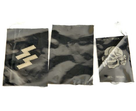A pair of Third Reich SS woven collar patches, consisting of a blank black patch and a basic SS runes patch, uncut on section