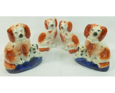 Three pairs of Staffordshire pottery spaniels, the largest with black markings and yellow eyes, 27cm high, a pair of liver an