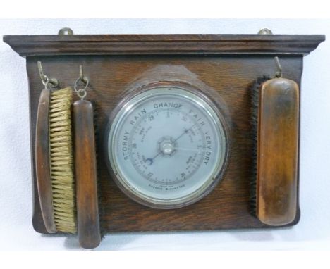 A aneroid barometer, circa 1920s, 14.5cm diameter, on oak mount with three brushes, the mount 25.5cm x 39.5cm CONDITION REPOR