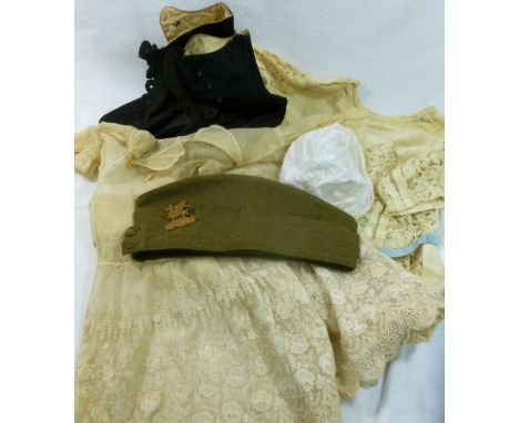 A collection of early 20th century clothing comprised of a pair of shoes, two young girl's dresses and a WWI army cap with ca