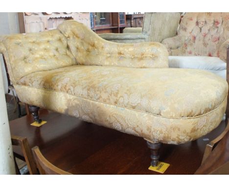 A Victorian scroll back chaise longue with button back upholstery on turned legs