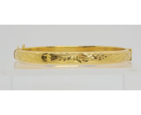 A 9ct gold engraved bangle of hollow construction, inner diameter 6cm, weight 8.4gms Condition Report:Available upon request