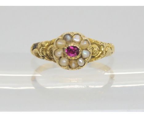A Victorian locket ring, the hinged cover set with a ruby and pearls, with a yellow metal flower embossed shank. Size M1/2, w