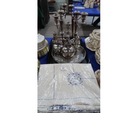 An embroidered table cloth, together with a pair of silver plated candelabra, a tray, an oak glass wall display cabinet etc C