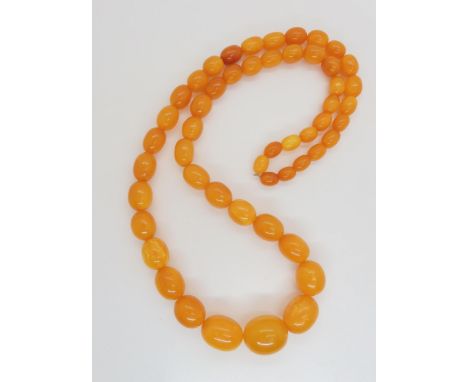 A string of amber coloured beads, light crazing and concoidial fractures throughout, largest bead 2cm x 1.6cm, approx 68cm lo