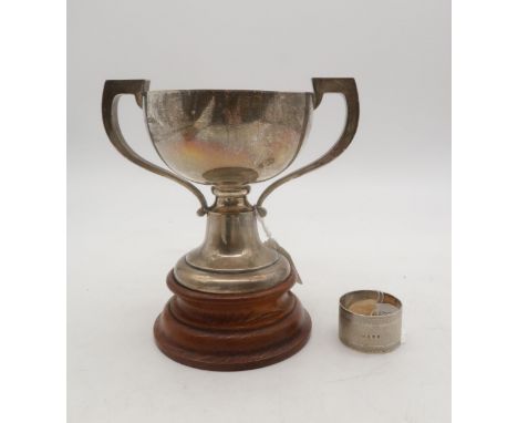 An Edwardian silver twin handled trophy cup, with a turned wooden base, by William Neale Ltd, Birmingham 1912, and a silver n