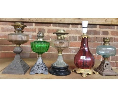 4 OIL LAMPS WITH GLASS RESERVOIRS &amp; 1 CRANBERRY COLOURED GLASS TABLE LAMP