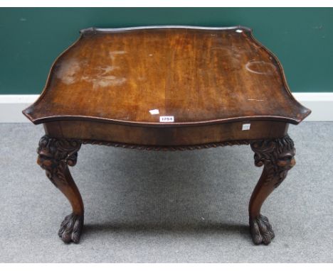 A mahogany coffee table of 18th century design, with serpentine square top on four cabriole supports carved with lion's face 