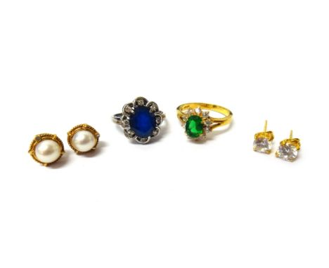 A diamond and synthetic sapphire set oval cluster ring, a gilt metal green and colourless paste set cluster ring, a pair of g