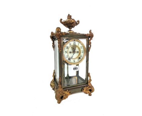 An Ansonia four glass mantel clock, early 20th century, with Rococo style urn finial and applied foliate embellishments, visi