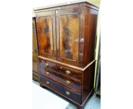 A George III mahogany linen press, the pair of panel doors over two short and two long drawers, on bracket feet, 123cm wide x