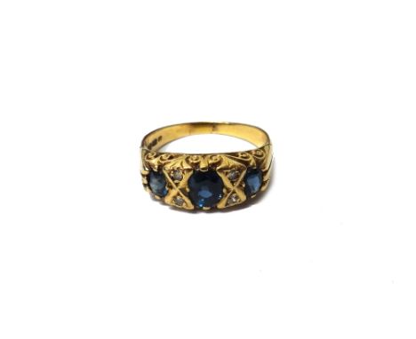 A 9ct gold, sapphire and diamond ring, mounted with three oval cut sapphires and with two pairs of circular cut diamonds moun