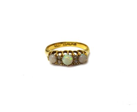 An 18ct gold, opal and diamond ring, mounted with three circular opals alternating with two pairs of cushion shaped diamonds,