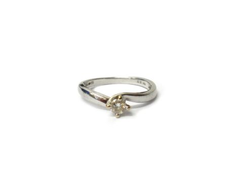 An 18ct white gold and diamond single stone ring, claw set with a circular cut diamond in a twistover design, detailed 0.15, 