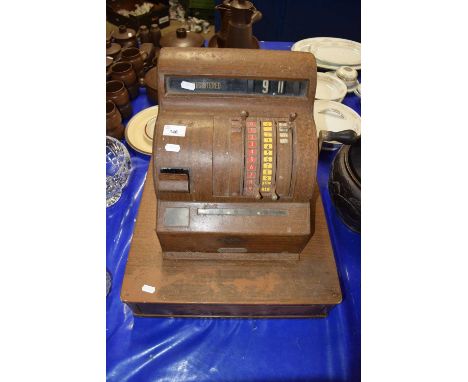 A vintage National Cash Register in wood grain effect metal case