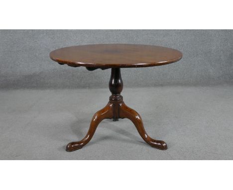 A 19th century walnut circular occasional table, with a turned baluster stem, on tripod supports with pad feet. H.59 Diam.80c