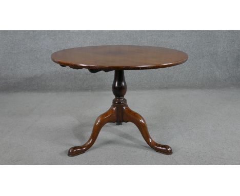 A 19th century walnut circular occasional table, with a turned baluster stem, on tripod supports with pad feet. H.59 Diam.80c