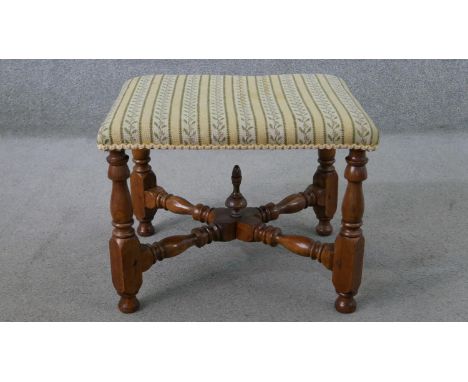 A Victorian walnut stool, upholstered in tapestry style fabric, on turned legs joined by turned X stretchers. H.38 W.50 D.42c