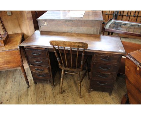 A 1940's eight drawer desk together with stick back kitchen chair