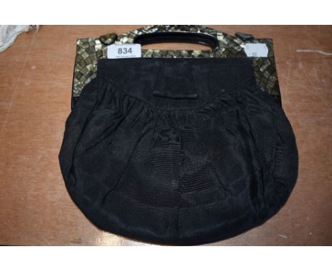 An early 20th century handbag having unusual shell like finish to framework handle, one clasp needs attention.