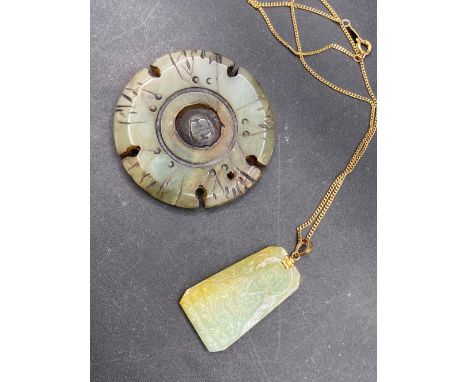 A large carved jade disc and a carved jade pendant
