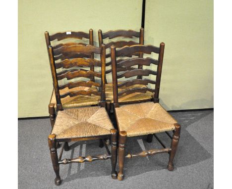 Four elm kitchen chairs with rush seats with scroll carved ladder backs