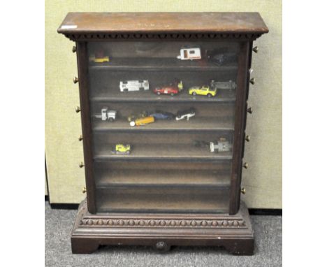 A mahogany cupboard with glazed front over egg and part carved base on bracket feet with projecting cornice set with six side