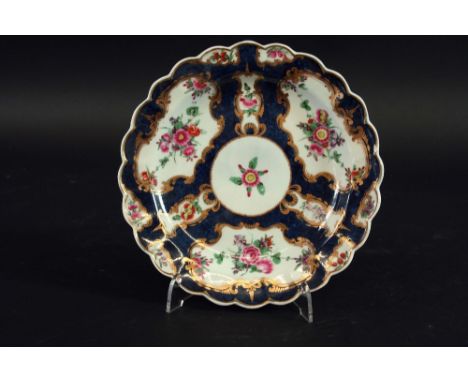 A PAIR OF FIRST PERIOD WORCESTER POLYCHROME PLATES each painted with floral swags within gilt mirror or vase cartouches reser