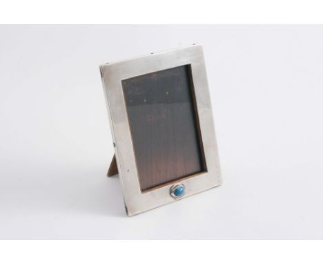 BY LIBERTY & CO: A small oblong photograph frame with a wooden easel back (stamped on the hinge with Pat.No. 234608). the fro