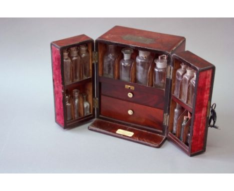 AN APOTHECARY'S CABINET with a flushed brass carrying handle and caddy moulded edges, the front dividing and opening to revea