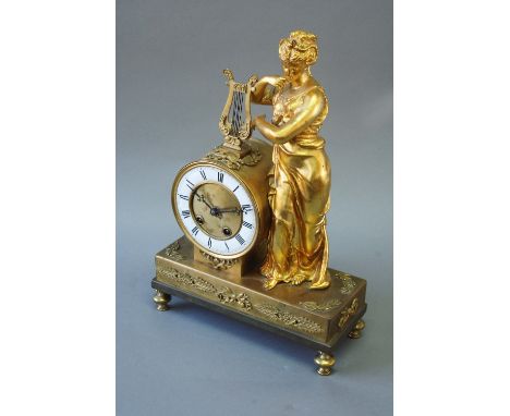 A GILT COLOURED MANTEL CLOCK dial white enamel annular, movement drum with lever escapement striking on a bell, 17ins. (43cms