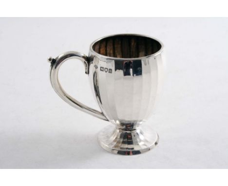 A MUG with a faceted oviform body & a pedestal foot, by the Goldsmiths & Silversmiths Co.Ltd., London 1913;  3.3"  (8.5 cms) 