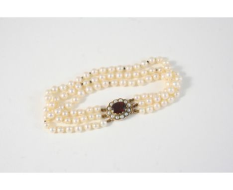 A THREE ROW UNIFORM CULTURED PEARL BRACELET the pearls measure approximately 4.6mm., and are set to a garnet, cultured pearl 