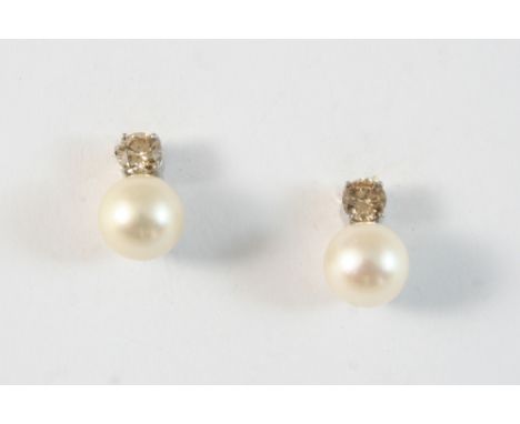 A PAIR OF DIAMOND AND CULTURED PEARL EARRINGS each set with a cinnamon brilliant-cut diamond and a cultured pearl measuring a