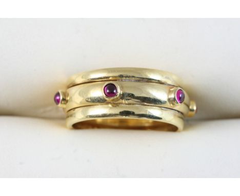 A GOLD BAND RING set with circular cabochon garnets. Size R.