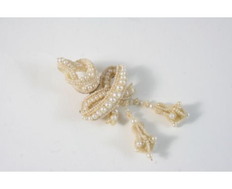A VICTORIAN PEARL BROOCH formed with graduated pearls and seed pearls and backed with mother-of-pearl, 8cm. long.