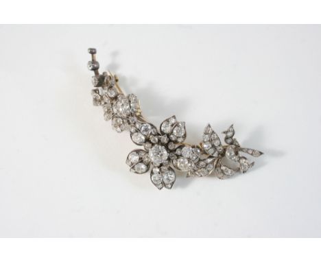 A LATE VICTORIAN DIAMOND BROOCH designed as a floral spray, set throughout with cushion shaped diamonds, the largest claw set