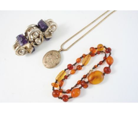 AN AMBER BEAD NECKLACE 51cm. long, 26 grams, a silver and carved amethyst bracelet and a gilt metal oval-shaped locket pendan