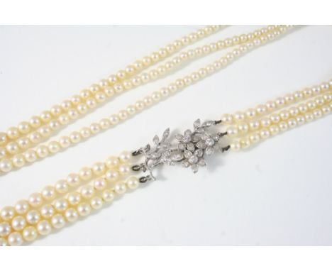 A THREE ROW GRADUATED CULTURED PEARL NECKLACE the pearls graduate from approximately 5.1mm to 7.3mm. to a diamond set foliate