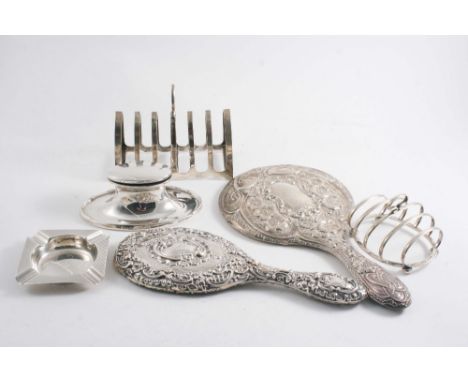 A MIXED LOT: An oval capstan inkwell glass liner, (loaded base), two toast racks, an ashtray & two embossed hand mirrors;  th