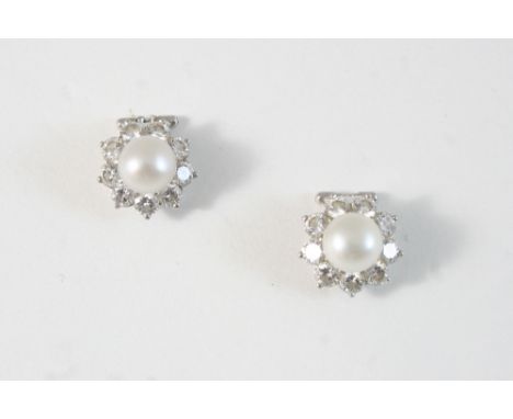 A PAIR OF CULTURED PEARL AND DIAMOND CLUSTER EARRINGS each set with a cultured pearl within a surround of nine circular-cut d