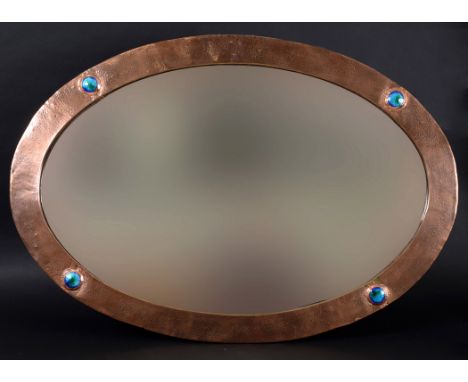LARGE ARTS &amp; CRAFTS MIRROR a large oval copper mirror, with a beaten finish and four enamel roundels. Unmarked, 39ins (99