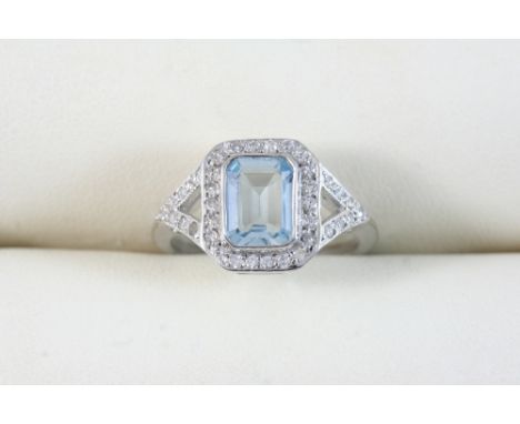 AN AQUAMARINE AND DIAMOND CLUSTER RING the step-cut aquamarine is set within a surround of circular-cut diamonds, with furthe