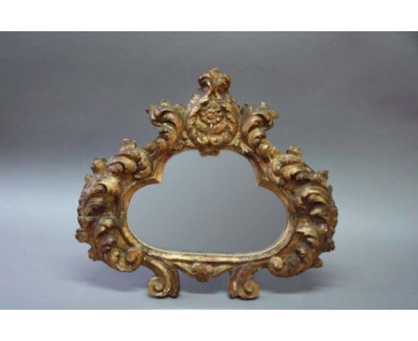 AN ITALIAN GILTWOOD EASEL LOOKING GLASS with bold acanthus foliage frame, 21 1/4ins. (54cms.) high x 23 1/2ins. (60cms.) wide