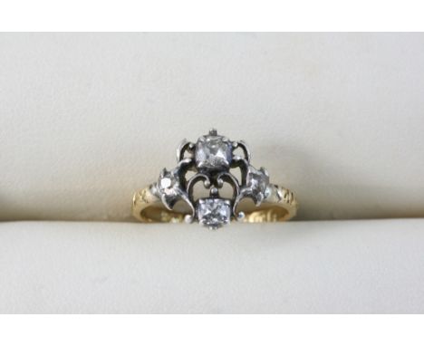 A GEORGIAN DIAMOND RING set with four cushion-shaped diamonds, in silver and gold. Size I.