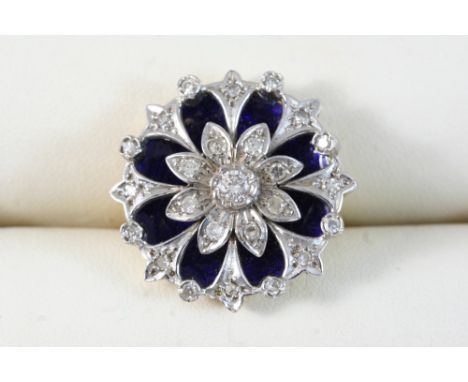 A DIAMOND AND ENAMEL RING of flowerhead design, set with graduated circular-cut diamonds on a blue enamel background, in 18ct