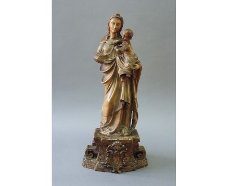 A MALINES ALABASTER MADONNA AND CHILD on a bow front plinth carved in high relief, with a cartouche surmounted by a winged ch